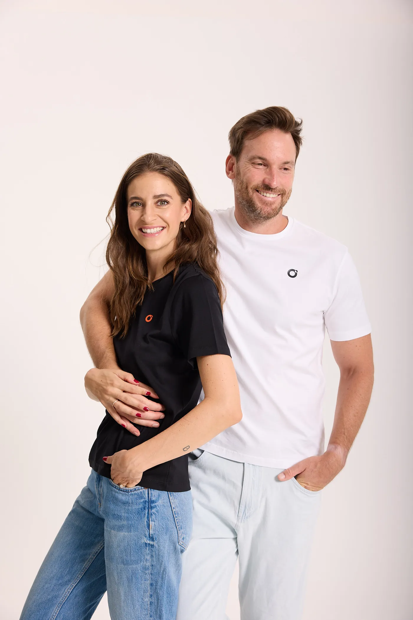 Zwei Menschen tragen das Genesis Tee, er in Schwarz, sie in Weiß